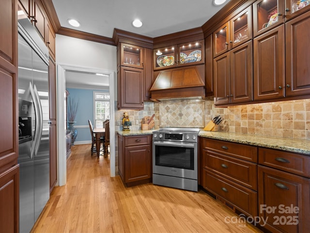 kitchen featuring backsplash, stainless steel appliances, custom exhaust hood, and crown molding