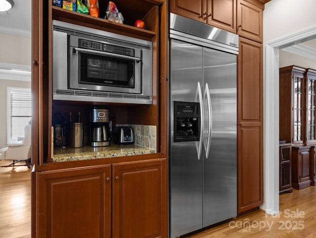 kitchen with light wood-style floors, built in fridge, and crown molding