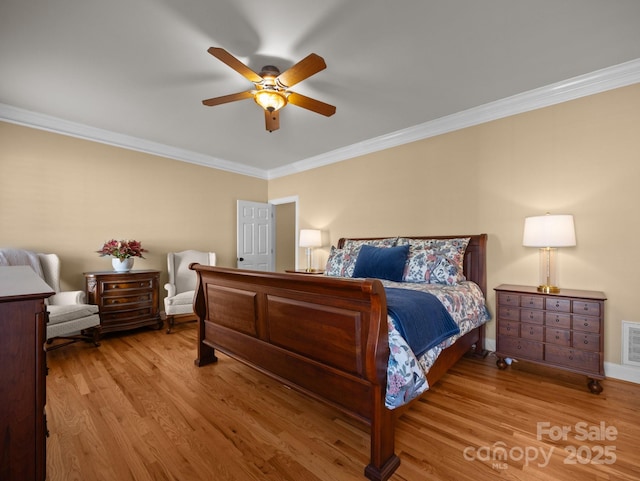 bedroom featuring visible vents, crown molding, ceiling fan, and wood finished floors