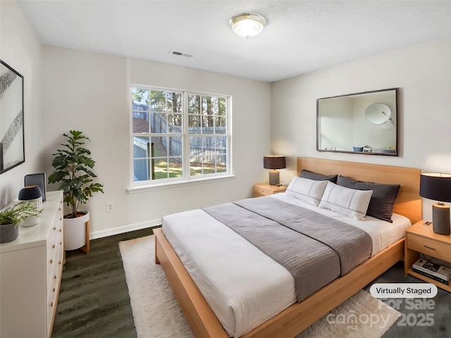 bedroom featuring visible vents, dark wood finished floors, and baseboards