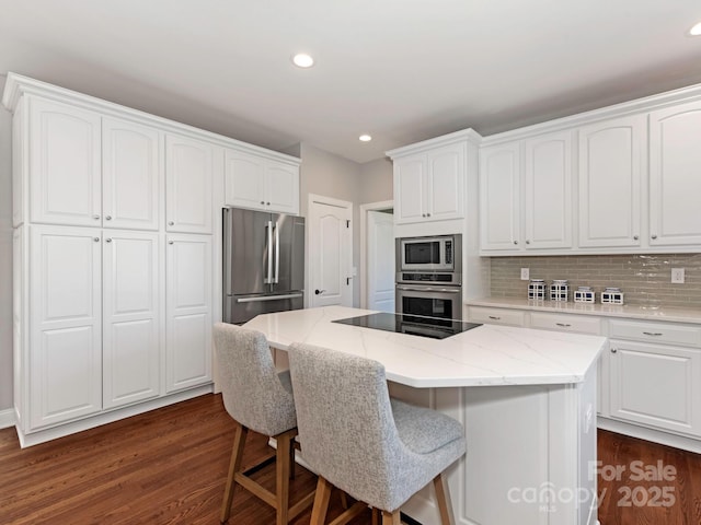 kitchen featuring stainless steel appliances, a kitchen island, and white cabinetry