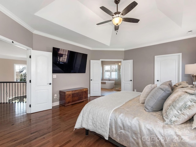 bedroom featuring wood finished floors, baseboards, visible vents, a tray ceiling, and crown molding