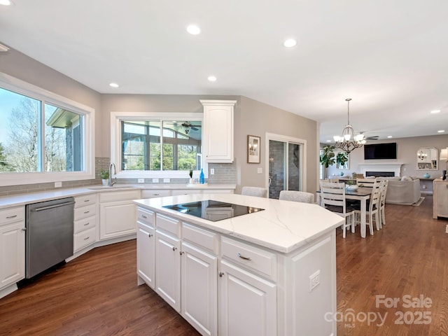 kitchen with a kitchen island, dishwasher, dark wood-style flooring, black electric cooktop, and a sink