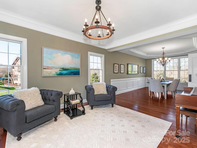 living room featuring crown molding, a notable chandelier, and wood finished floors