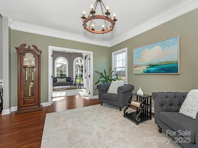 interior space with baseboards, wood finished floors, a chandelier, and crown molding