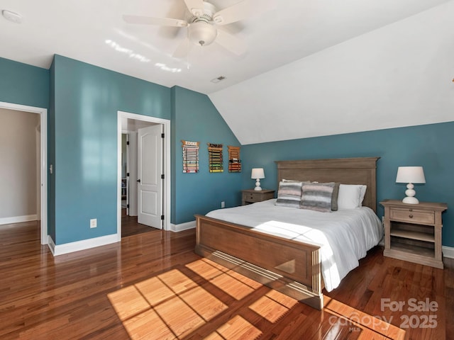 bedroom with wood finished floors, visible vents, baseboards, ceiling fan, and vaulted ceiling