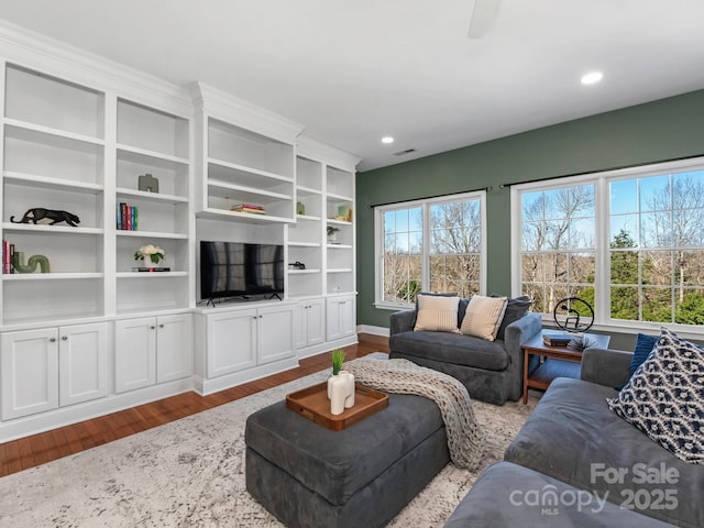 living room with recessed lighting, wood finished floors, and visible vents