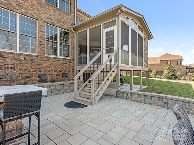 view of patio featuring stairs and a sunroom