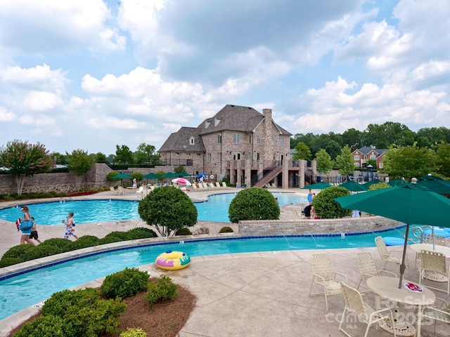 pool with a patio area and fence