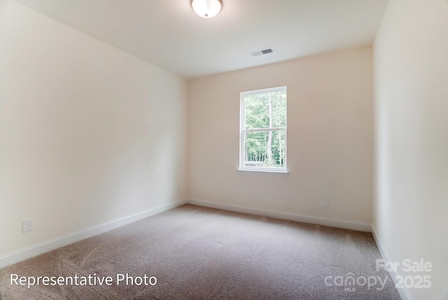 spare room featuring visible vents, baseboards, and carpet flooring