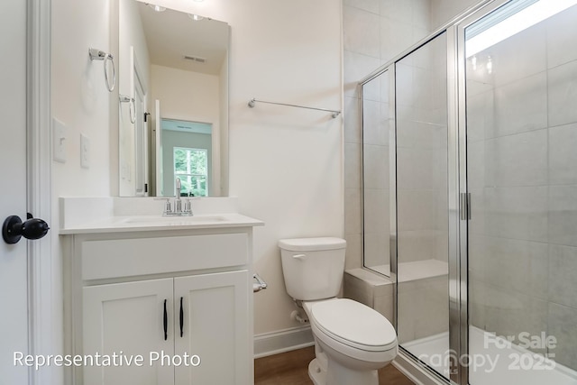 bathroom with visible vents, toilet, a stall shower, baseboards, and vanity