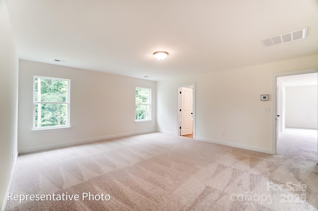 carpeted empty room with visible vents and baseboards