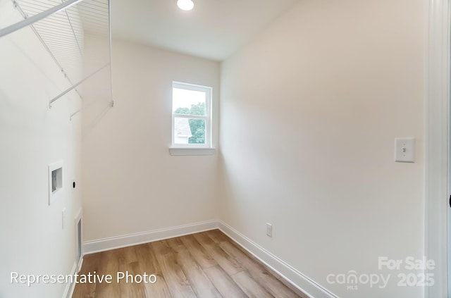 washroom featuring electric dryer hookup, light wood finished floors, baseboards, hookup for a washing machine, and laundry area