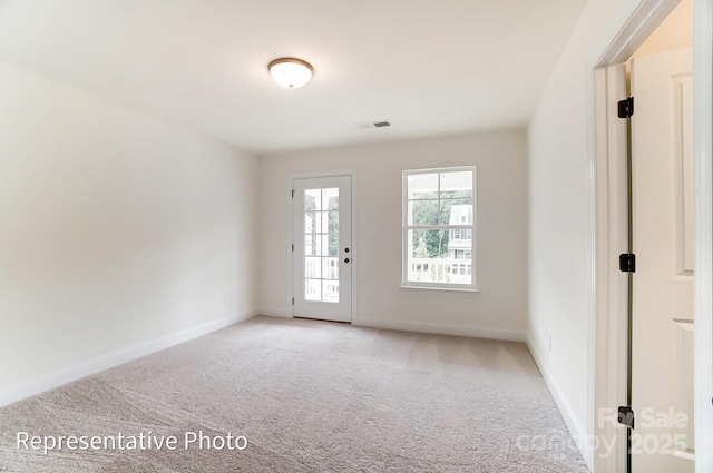 doorway featuring visible vents, baseboards, and light colored carpet