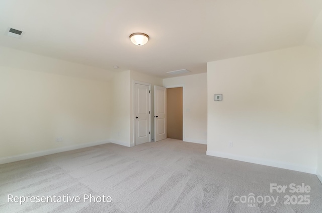 unfurnished room with visible vents, baseboards, and light carpet