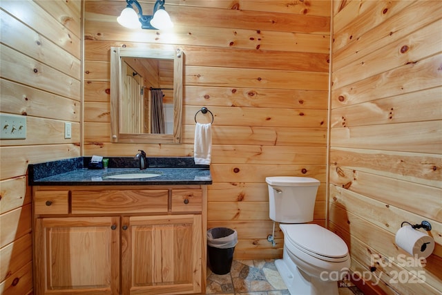 bathroom with stone finish flooring, wooden walls, and toilet