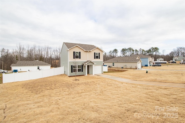 traditional-style home with board and batten siding, fence, driveway, and a garage