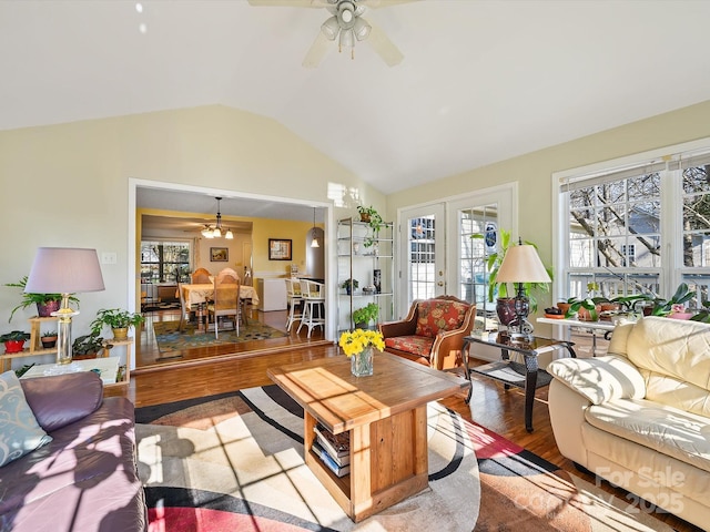 living room with french doors, lofted ceiling, plenty of natural light, and wood finished floors