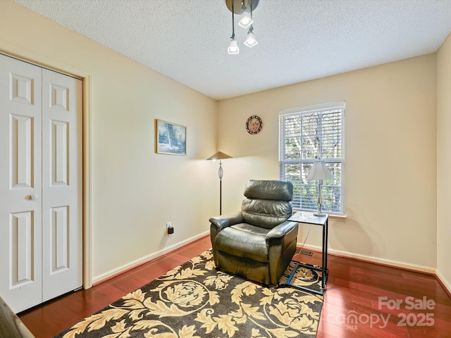 sitting room featuring wood finished floors, baseboards, and a textured ceiling