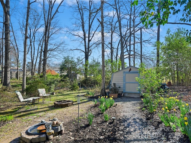 view of yard with a storage unit, an outdoor fire pit, and an outbuilding