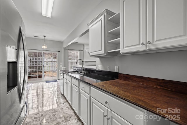 11712 Huxley Rd, Charlotte, NC 28277 - kitchen featuring dark countertops, a sink, appliances with stainless steel finishes, white cabinets, and open shelves