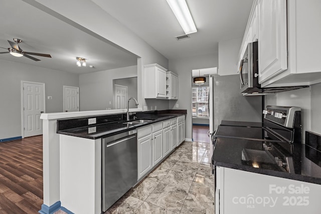 11712 Huxley Rd, Charlotte, NC 28277 - kitchen featuring visible vents, a peninsula, a sink, stainless steel appliances, and white cabinets