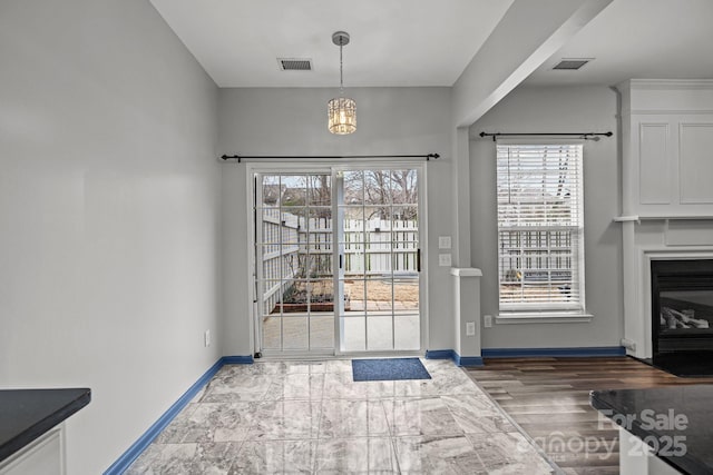 11712 Huxley Rd, Charlotte, NC 28277 - doorway to outside with a chandelier, visible vents, baseboards, and a glass covered fireplace