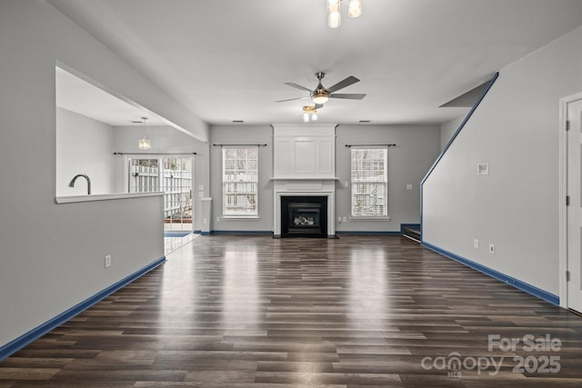 11712 Huxley Rd, Charlotte, NC 28277 - unfurnished living room with a fireplace, baseboards, ceiling fan, and dark wood-style flooring