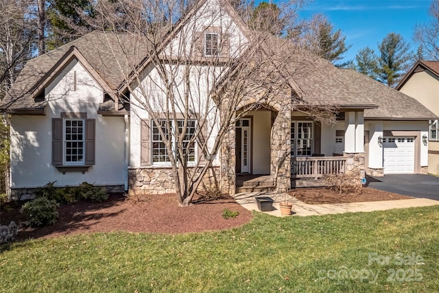 view of front of home with a shingled roof, stucco siding, covered porch, a garage, and stone siding