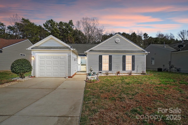 ranch-style home featuring a yard, central AC unit, a garage, and driveway