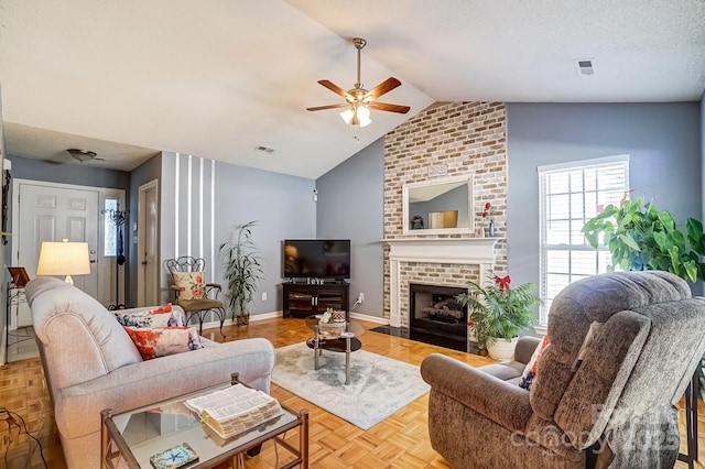 living area with lofted ceiling, a ceiling fan, a textured ceiling, a fireplace, and baseboards