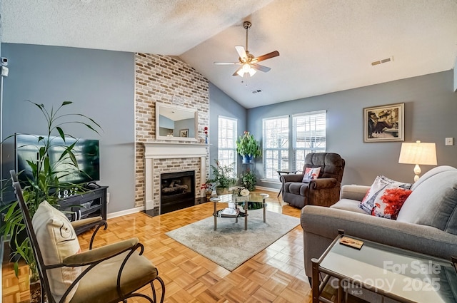 living area with visible vents, a ceiling fan, a textured ceiling, a fireplace, and vaulted ceiling