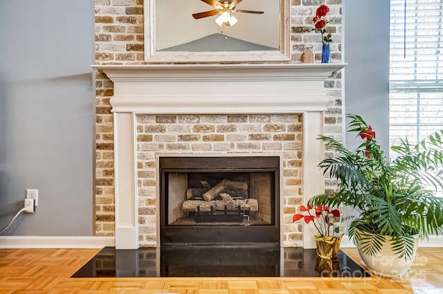 interior details with a brick fireplace and ceiling fan