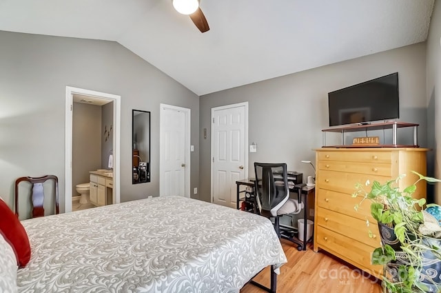 bedroom featuring ceiling fan, lofted ceiling, wood finished floors, and ensuite bathroom