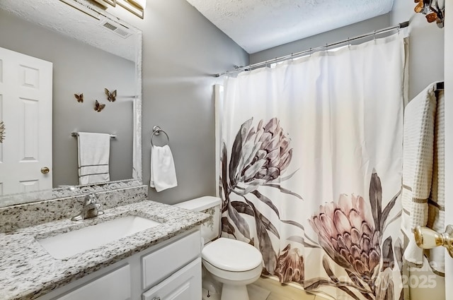 bathroom featuring vanity, toilet, visible vents, and a textured ceiling