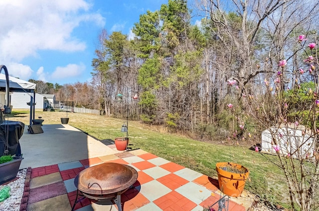 view of yard with a patio area, an outdoor fire pit, and fence