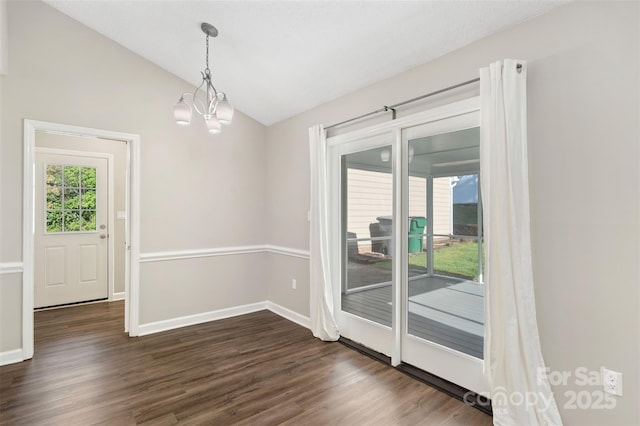 unfurnished dining area featuring a chandelier, dark wood-style flooring, baseboards, and vaulted ceiling
