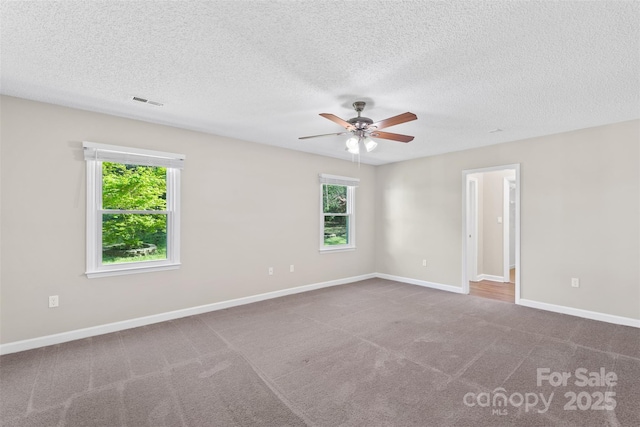 unfurnished room featuring baseboards, carpet flooring, ceiling fan, and a textured ceiling