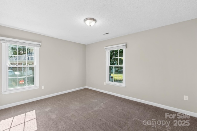 unfurnished room featuring baseboards, a textured ceiling, visible vents, and carpet