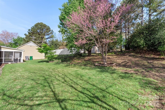 view of yard featuring a sunroom and fence