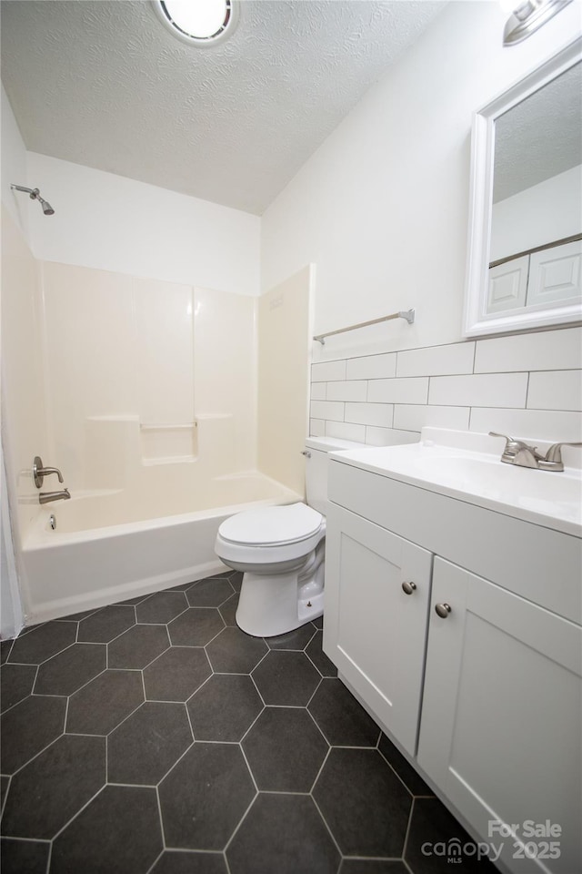 full bathroom featuring a textured ceiling, bathtub / shower combination, toilet, vanity, and tile patterned floors