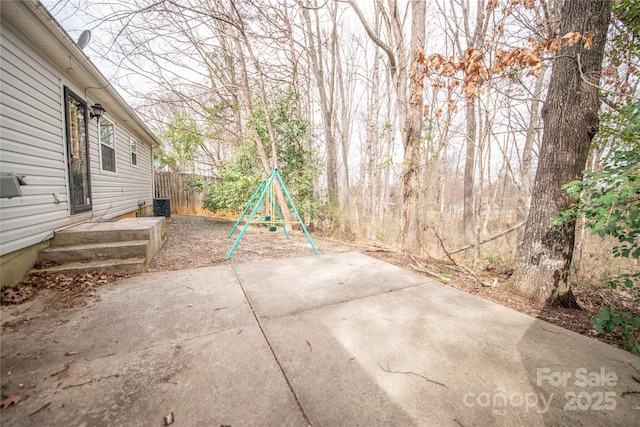 view of patio featuring fence and a playground