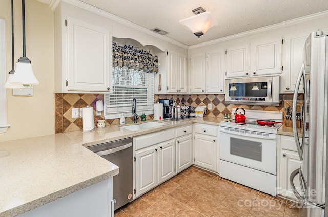 kitchen featuring visible vents, decorative backsplash, appliances with stainless steel finishes, white cabinetry, and a sink