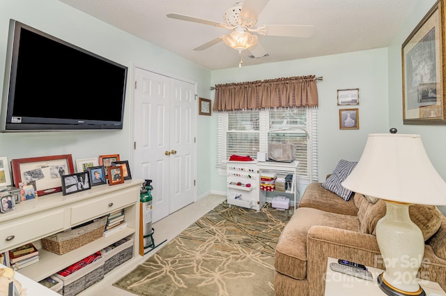 living area featuring a ceiling fan, carpet, and baseboards