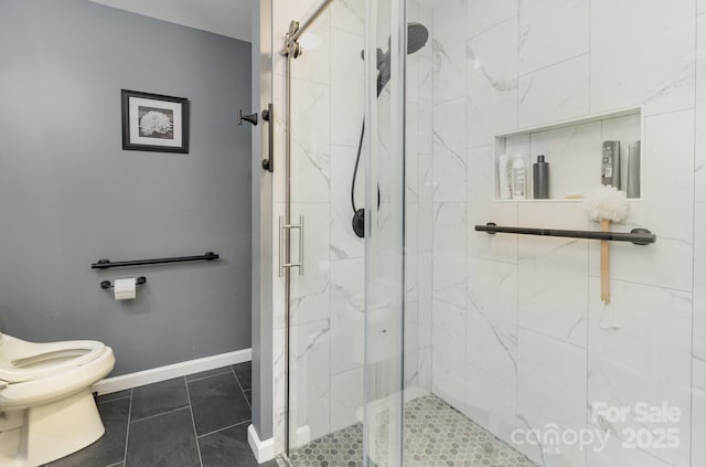 full bath with tile patterned flooring, baseboards, toilet, and a marble finish shower