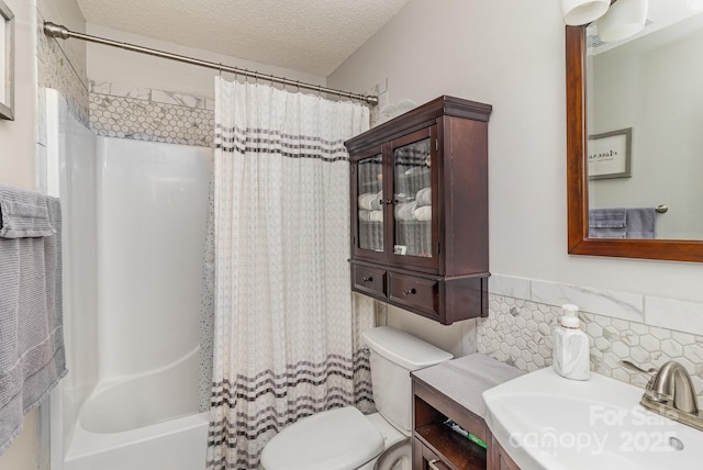 bathroom featuring toilet, shower / bath combo, a textured ceiling, and vanity