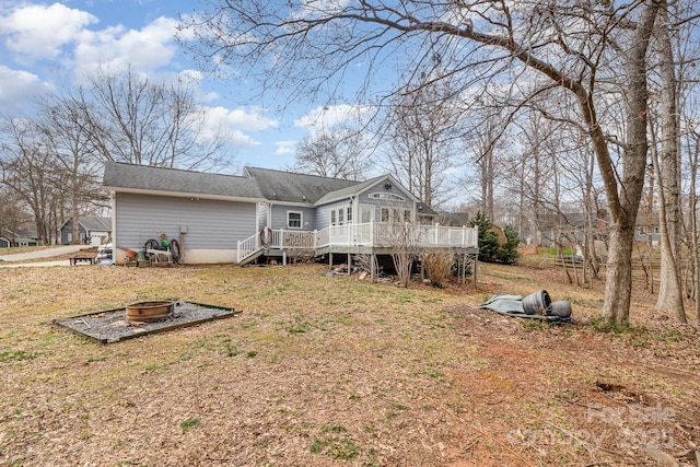 rear view of property with an outdoor fire pit and a wooden deck