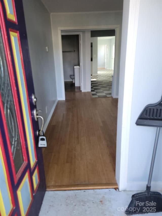 corridor featuring wood finished floors and baseboards