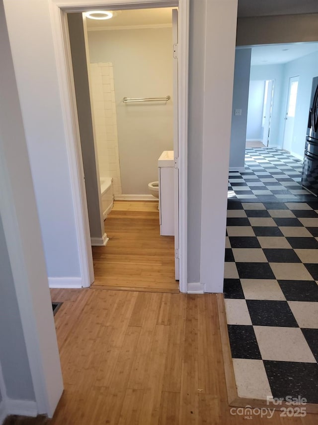 hallway featuring baseboards and tile patterned floors