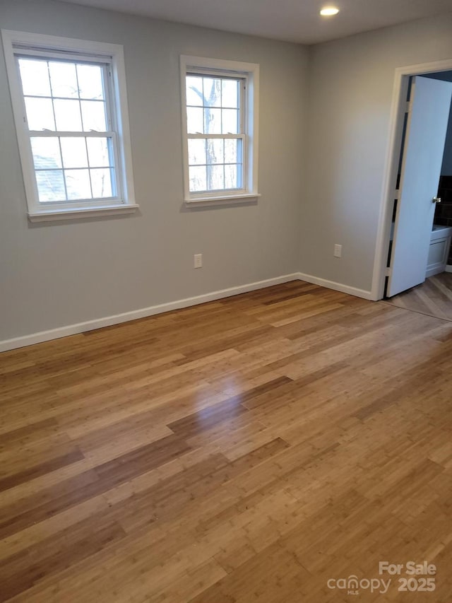 unfurnished room featuring light wood-style floors, recessed lighting, and baseboards